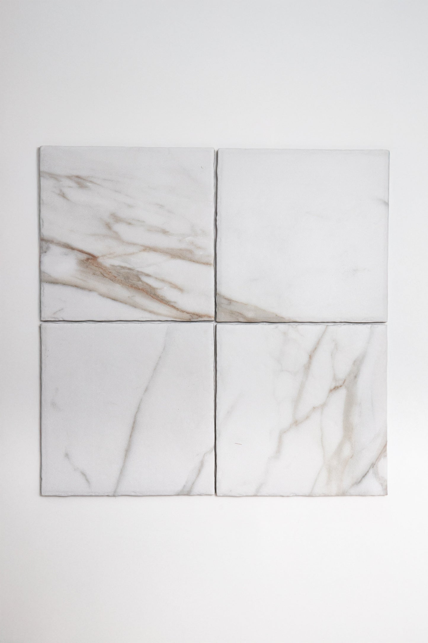 Four Tosca Macchia Vecchia marble tile samples with brown and gray veining arranged on a plain white background.