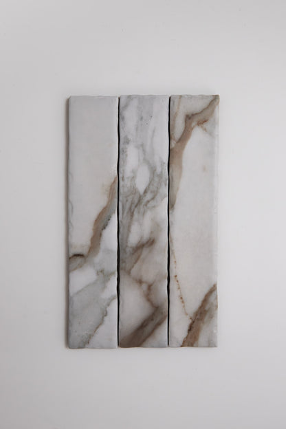 Three Tosca Macchia Vecchia marble samples with gray and brown veining, shown vertically on a white background.
