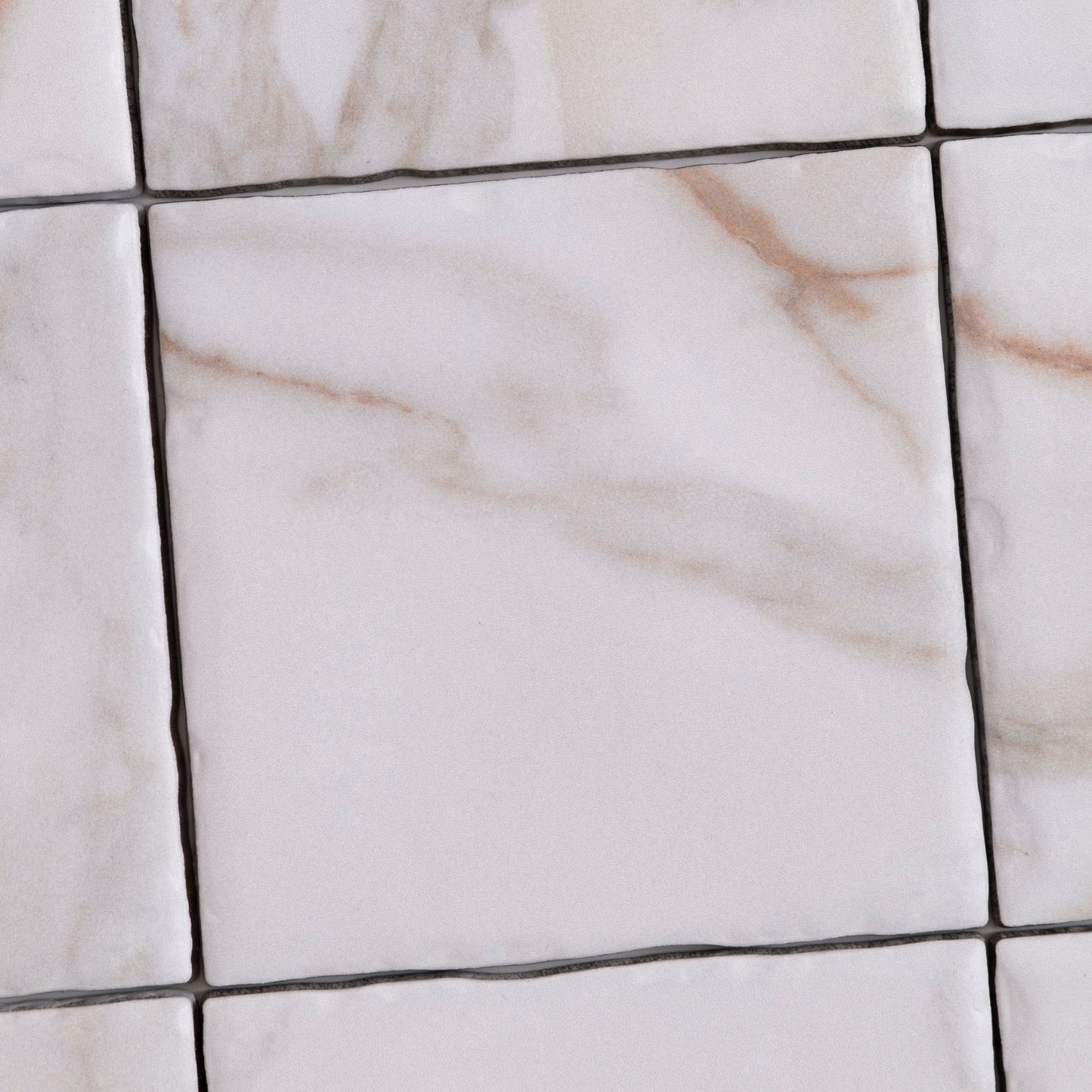 Tosca Macchia Vecchia Sample: white marble tiles with grey-beige veining, grid pattern, visible grout lines.