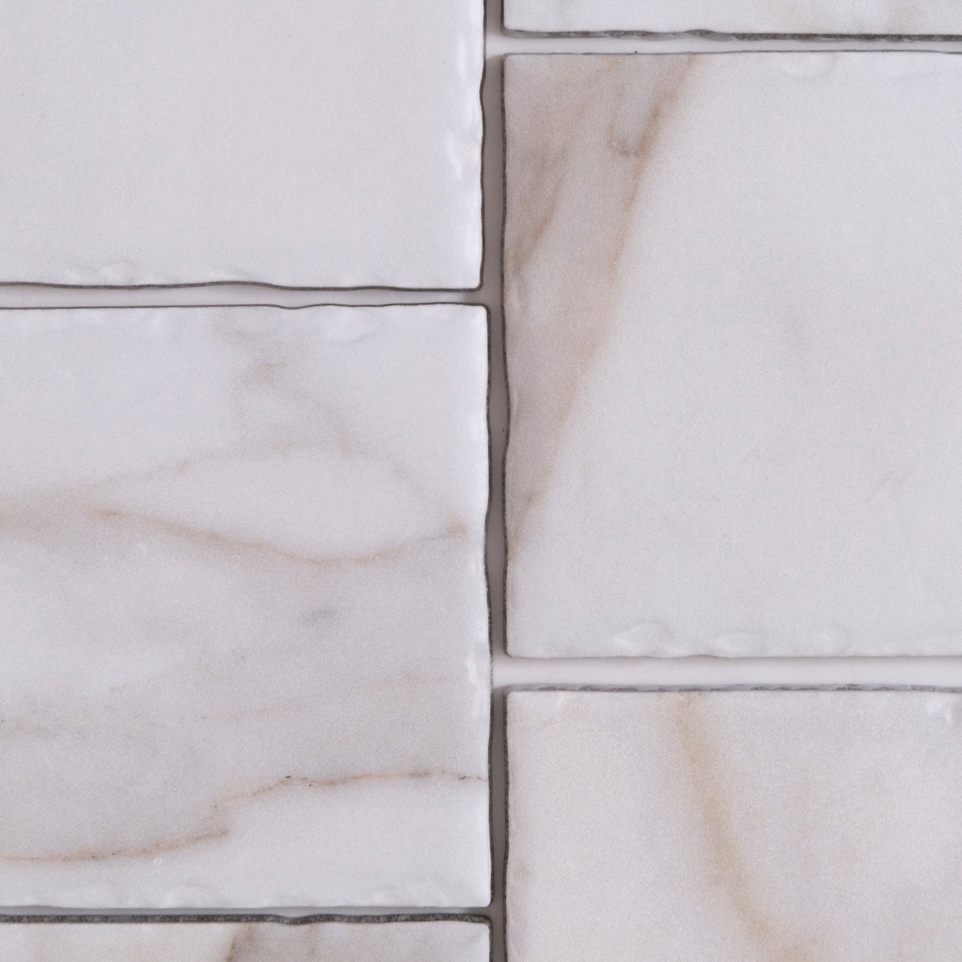 Close-up of Tosca's Macchia Vecchia, Extra Sample: light marble tiles with subtle veining and visible grout lines.