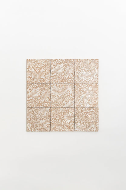 Nine Maisie Deco sample tiles by Cottage Ivy with nature-inspired beige patterns arranged in a square on a white wall.