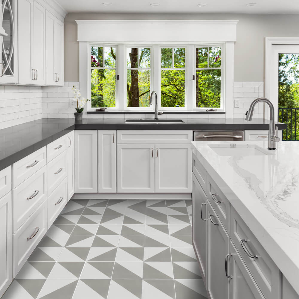 Modern white kitchen featuring New York Cement Tile’s N20-139 Soft Slate&White, gray counters, and large windows.
