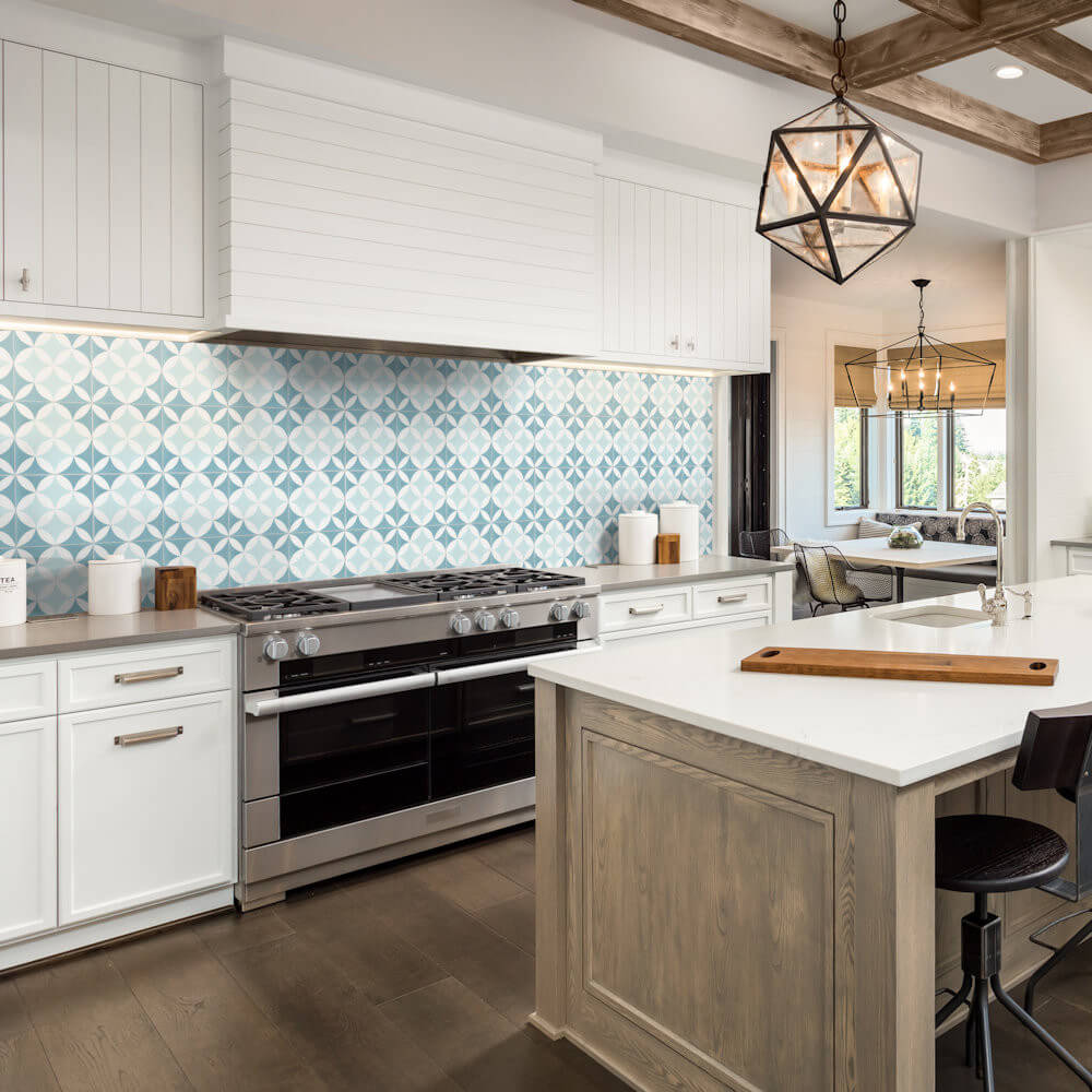 Modern kitchen with white cabinets, large stove, wooden island with white top, and N20-062 4400/2 blue tile by New York Cement Tile.