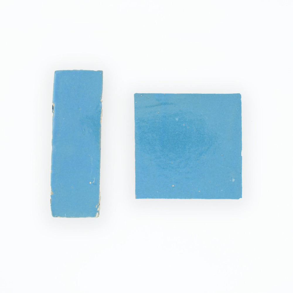 Two small blue Azure sample tiles from New York Cement Tile, one rectangular and one square, on a white background.