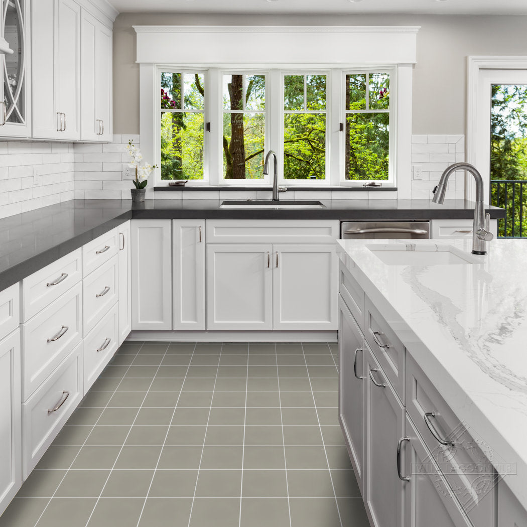 Bright white kitchen with 2215-Solid countertops by New York Cement Tile, tiled floor, and large windows to greenery.