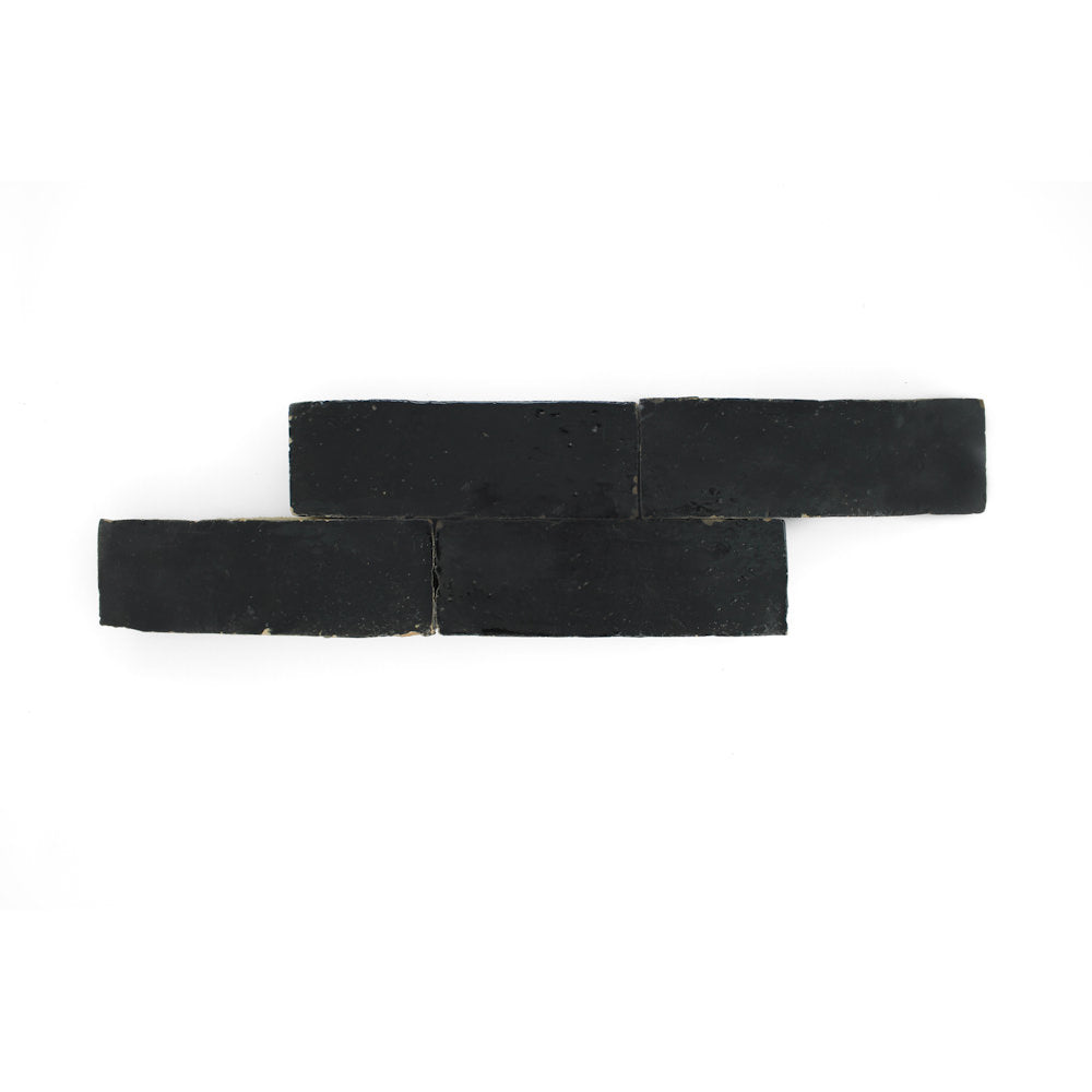 Four Black Onyx (2x6) samples by New York Cement Tile, in a staggered row on white, resemble handcrafted tile.
