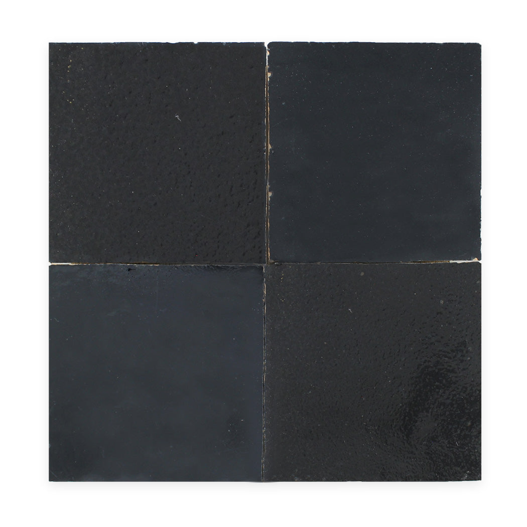 Four glossy black square tiles arranged in a 2x2 grid on a white background.