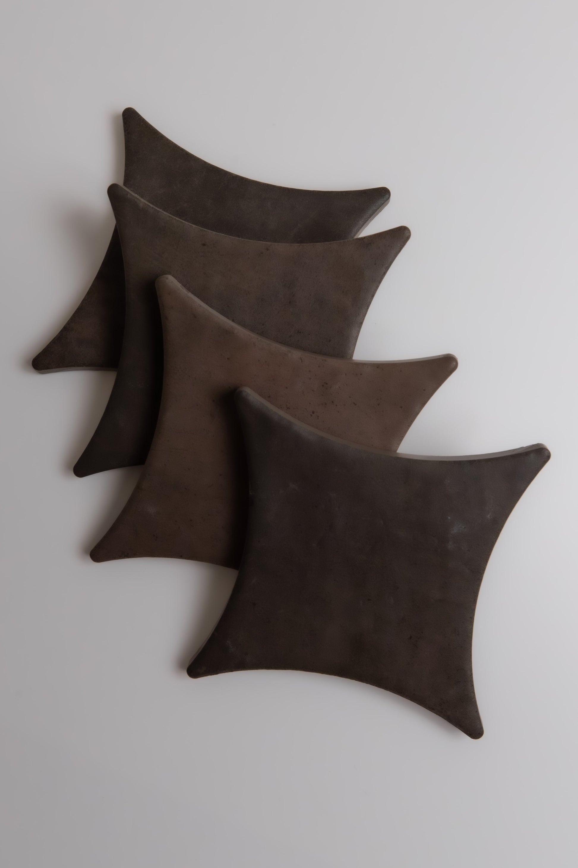 Four Ocre, Extra Sample pillows from Finca are arranged diagonally on a light surface.