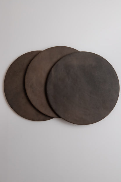 Three Finca Ocre, Extra Sample pizza stones overlap on a light surface.