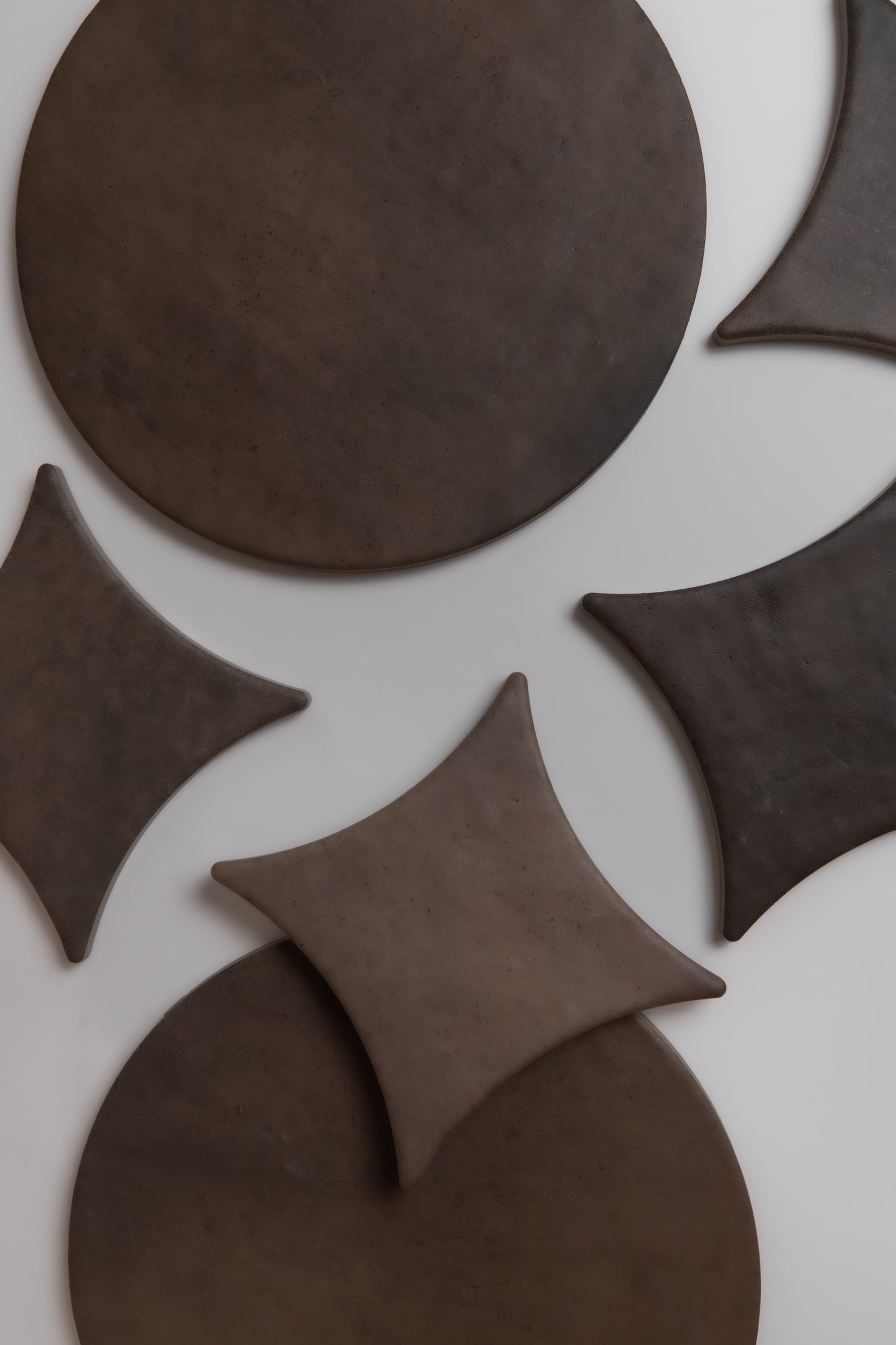 Ocre, Extra Sample by Finca: brown circular and diamond shapes on a light surface form a geometric abstract pattern.