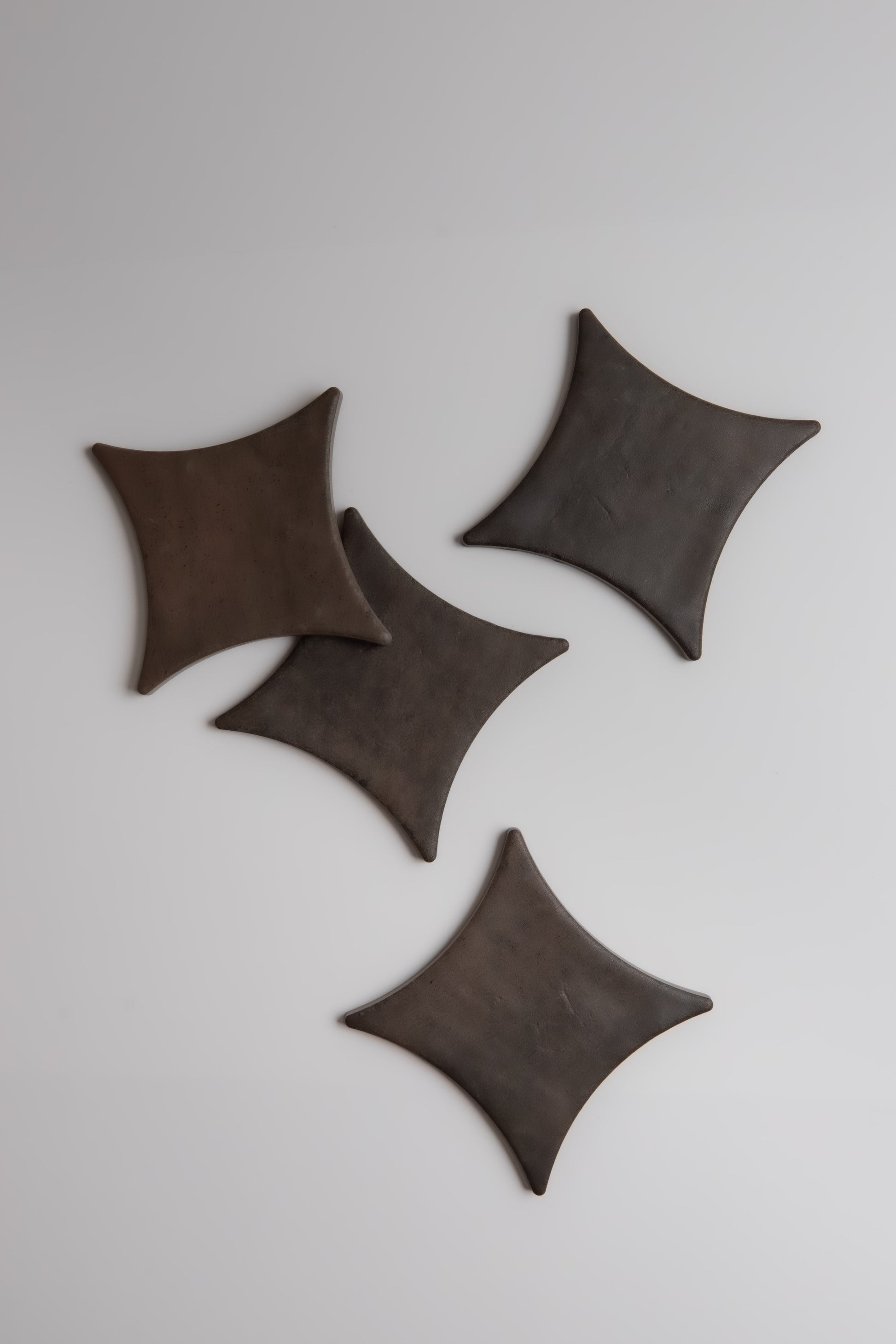 Four Ocre, Extra Sample leather coasters by Finca are displayed on a light gray background.