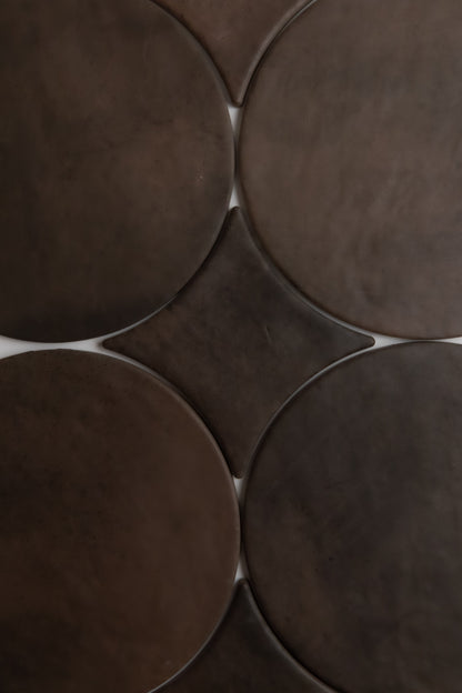 Close-up of Finca’s Ocre, Extra Sample: overlapping dark brown tiles form a geometric, abstract pattern.