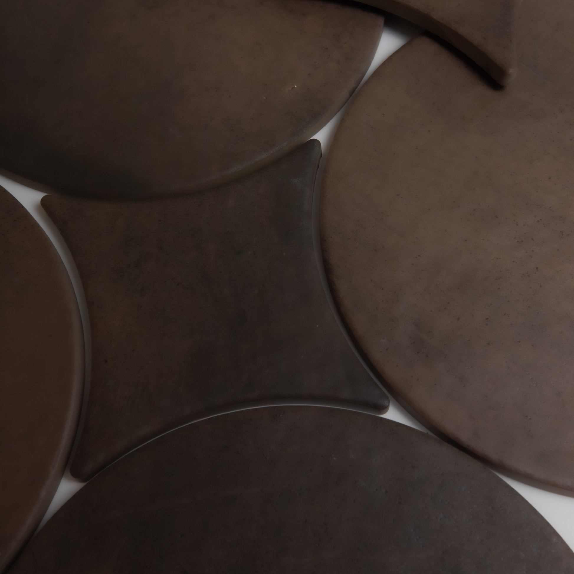 Finca’s Ocre, Extra Sample features overlapping round and square brown surfaces with smooth, matte textures.