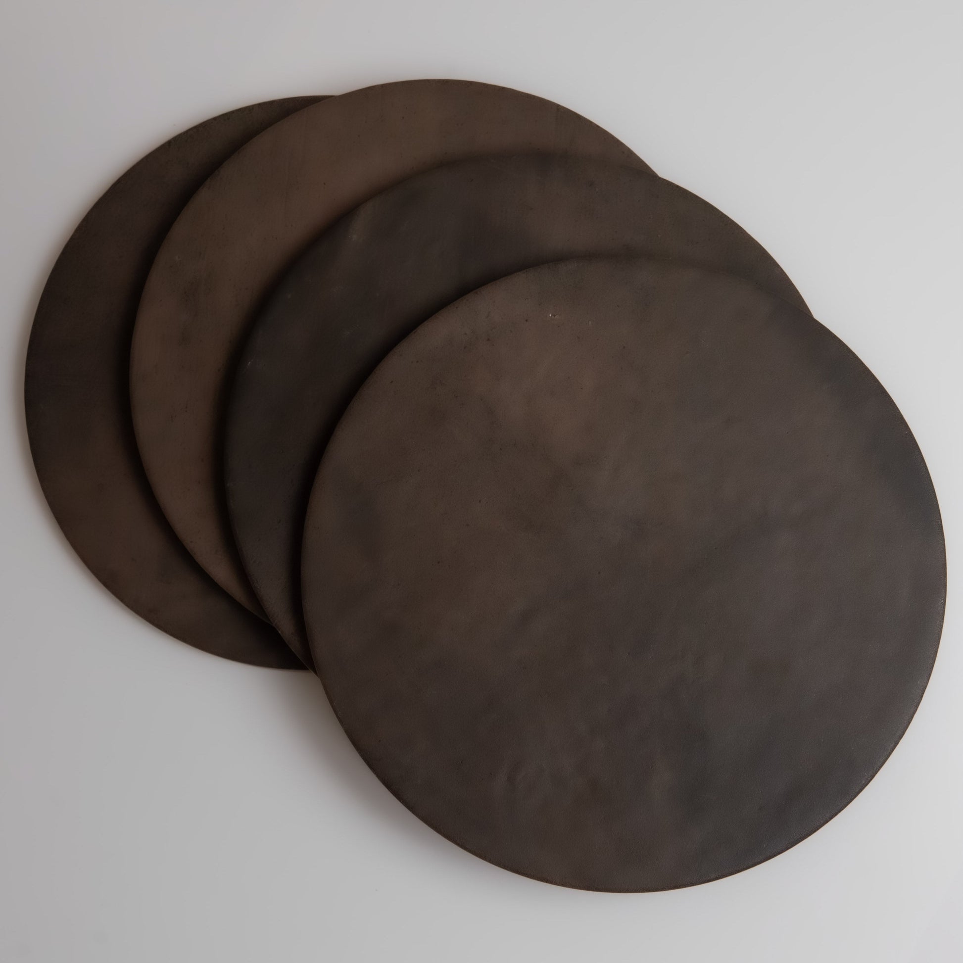 Four round Ocre, Extra Sample discs by Finca overlap on a light gray surface.
