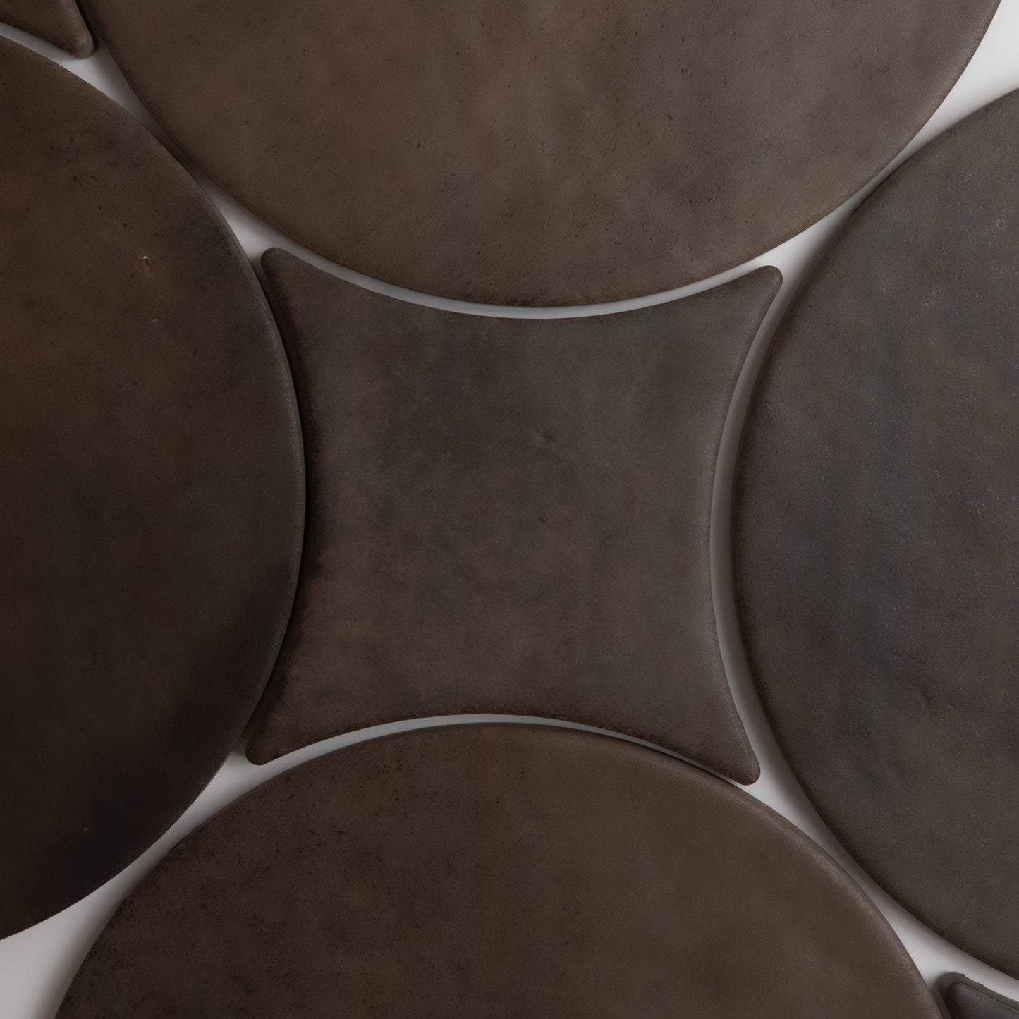 Five large, round dark brown Finca Ocre disks surround a central square shape with concave sides on a white background.