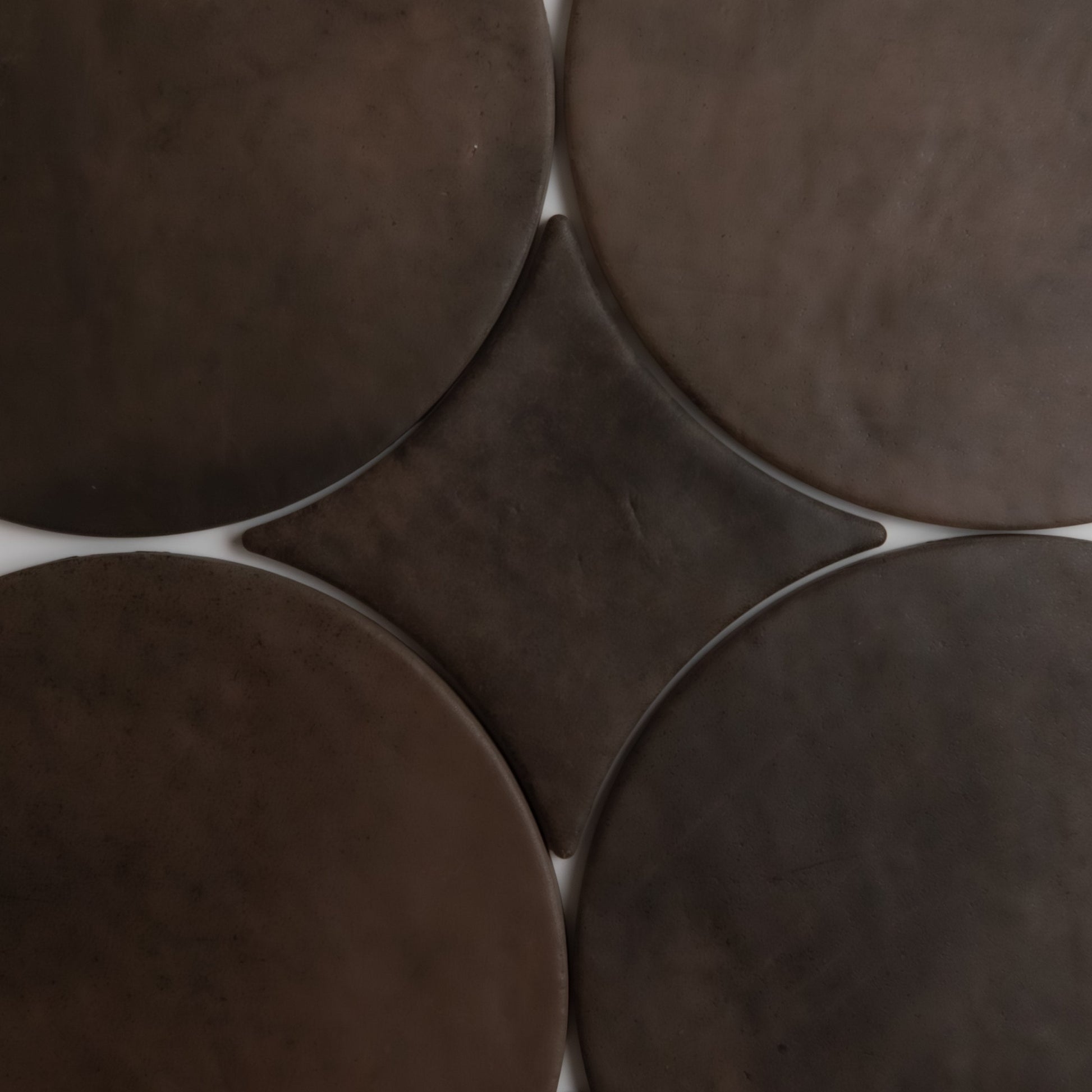 Four large brown Ocre, Extra Sample tiles by Finca surround a smaller diamond tile, creating a symmetrical design.