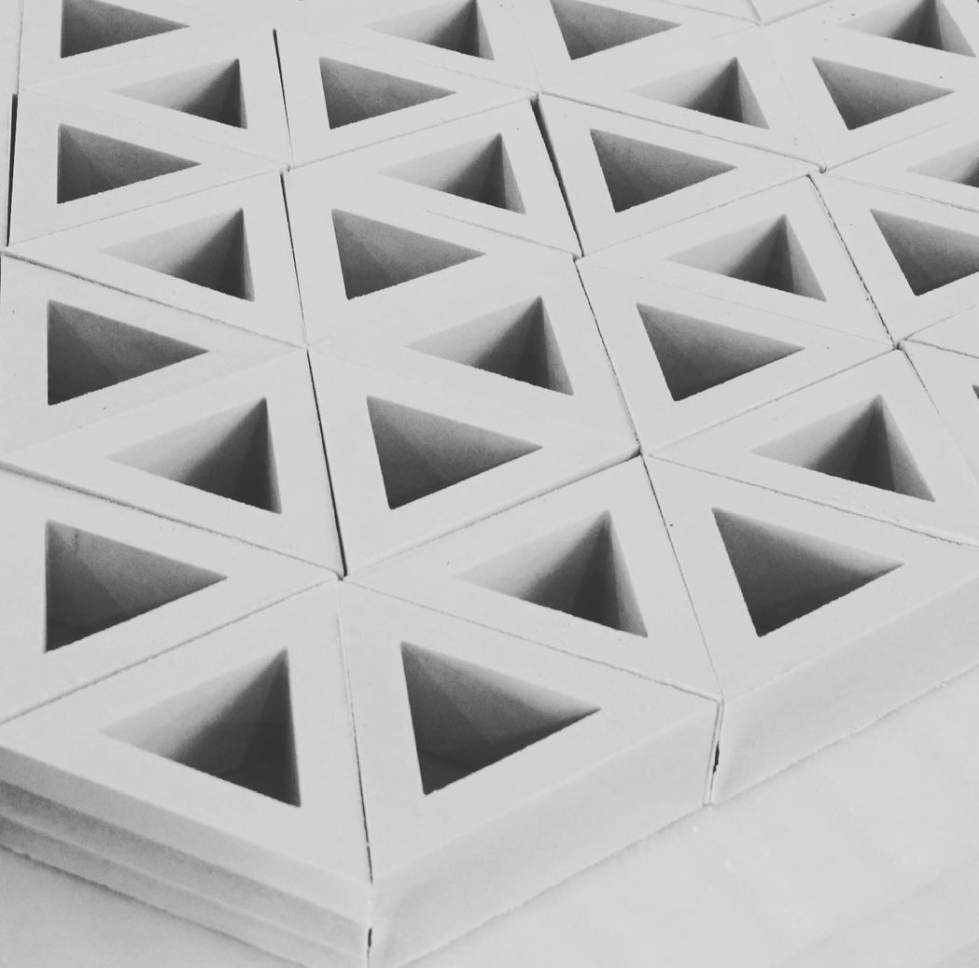 A pattern of white, hollow, triangular tiles arranged in a grid.