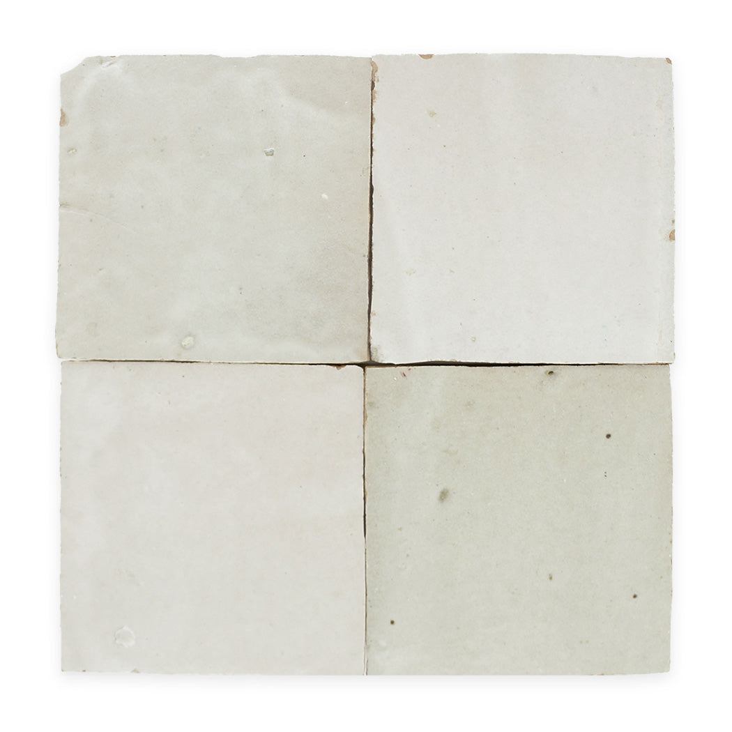 Four off-white, slightly textured square tiles arranged in a 2x2 grid with subtle imperfections and variations.