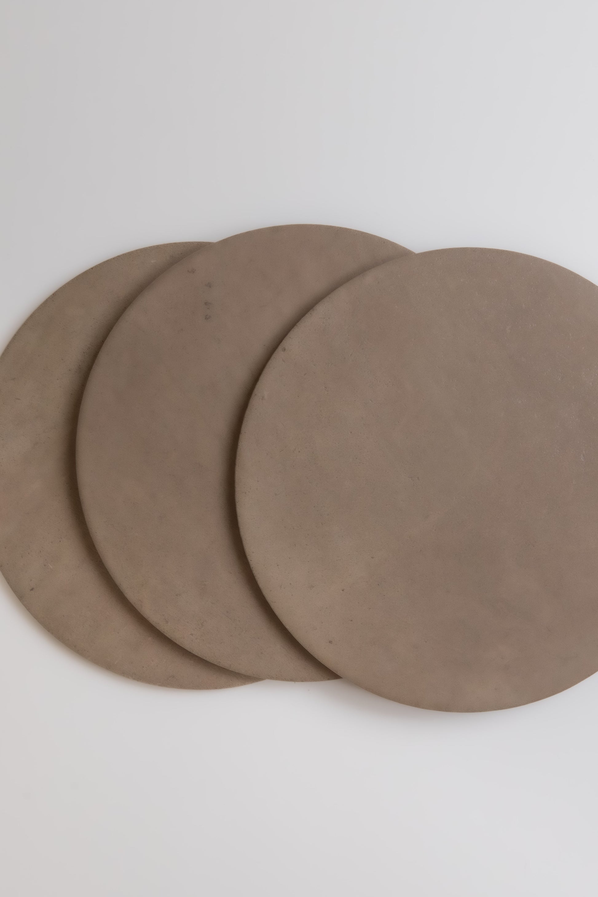 Three round Pampas flats from Finca, overlapping each other on a plain white background.