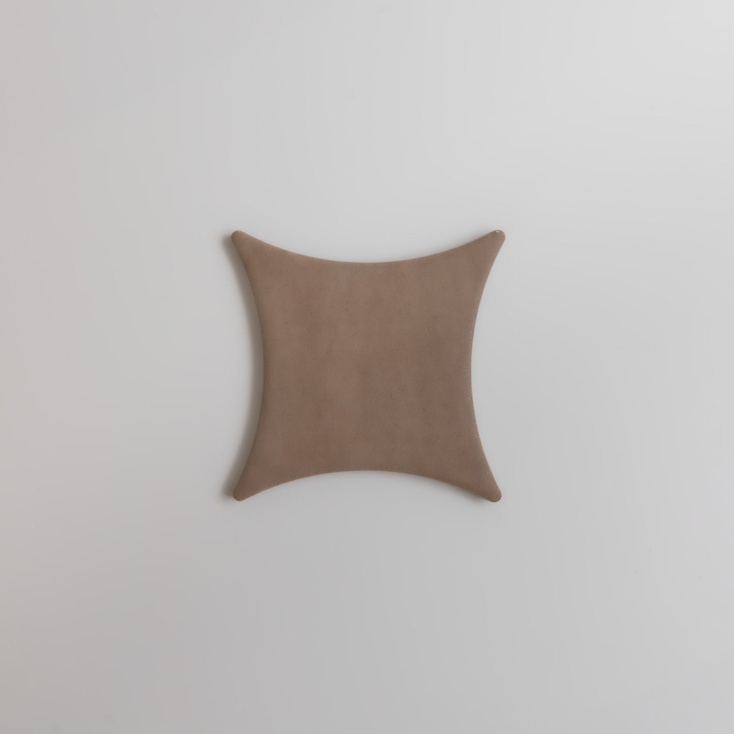 The Finca Pampas features a tan, square shape with concave sides and pointed corners on a white background.