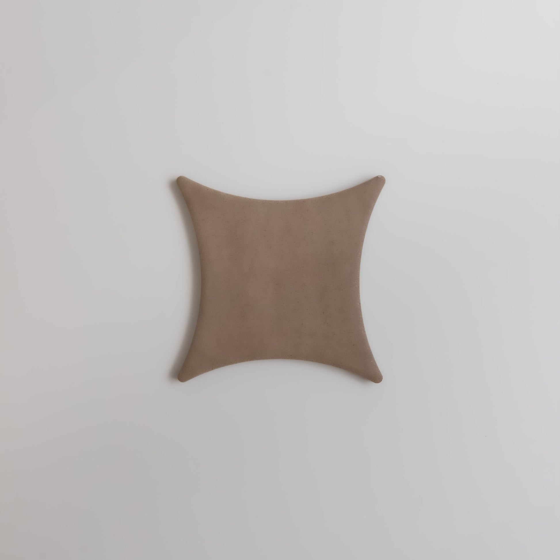 The Finca Pampas features a tan, square shape with concave sides and pointed corners on a white background.