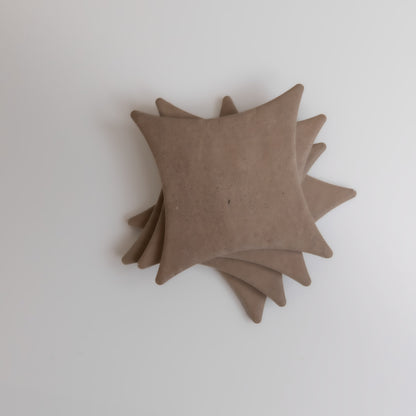 Five overlapping, square-shaped Pampas coasters by Finca with rounded edges on a plain white background.