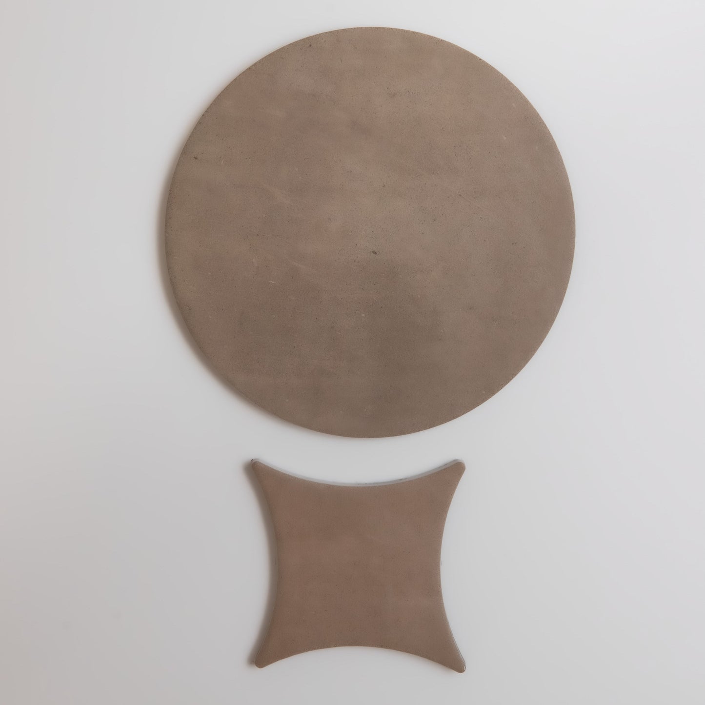 A Pampas, Sample by Finca: a round brown object atop a small curved square, shown on a white background.