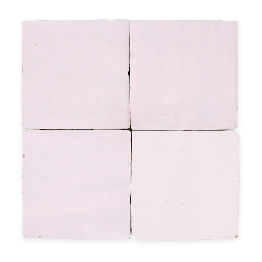 Four square, pale pink ceramic tiles arranged in a two-by-two grid against a white background.