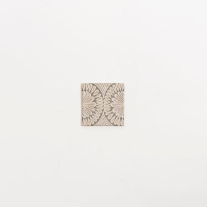 The Poppy Deco tile by Cottage Ivy features a beige petal geometric pattern on a light background, shown on white.