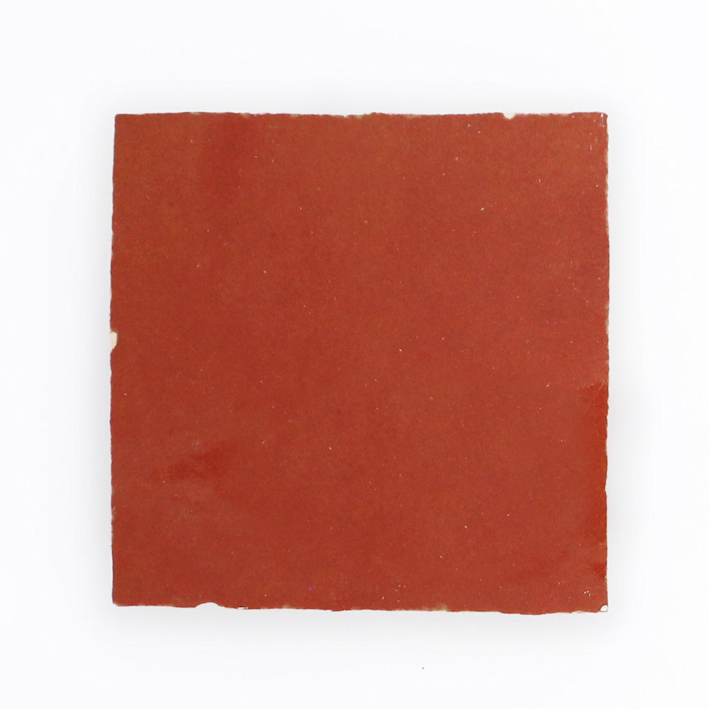 A single Fiery Red Zellige tile by New York Cement Tile with a slightly rough, matte surface on a white background.