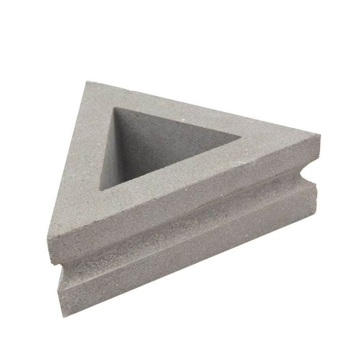 The Nui Triangular by New York Cement Tile is a gray, hollow-center breeze block with grooved edges for decorative walls.