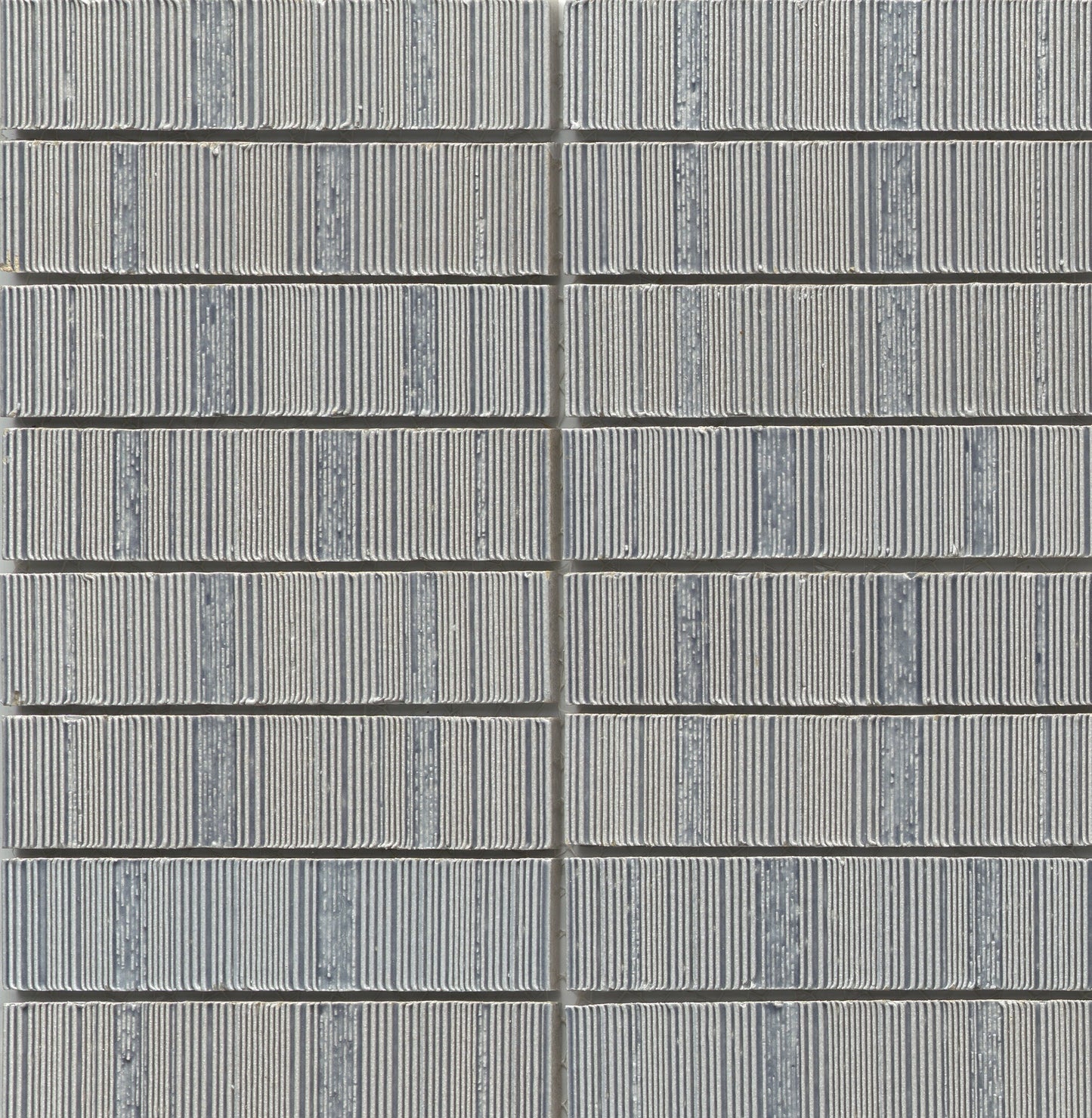 Close-up of Silver - Newtro - Sample tiles by New York Cement Tile, stacked in neat, geometric vertical columns.