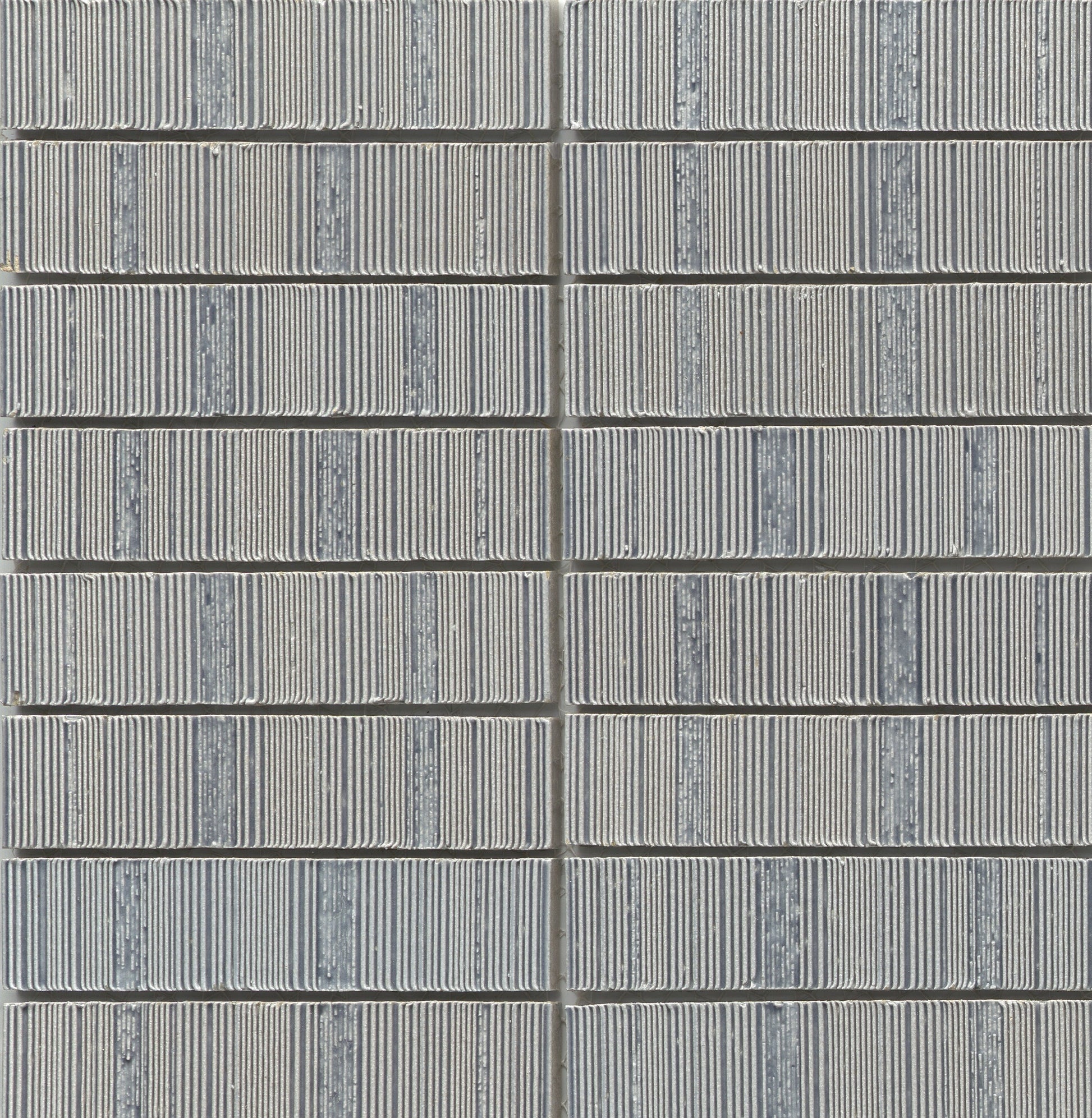 Close-up of Silver - Newtro - Sample tiles by New York Cement Tile, stacked in neat, geometric vertical columns.