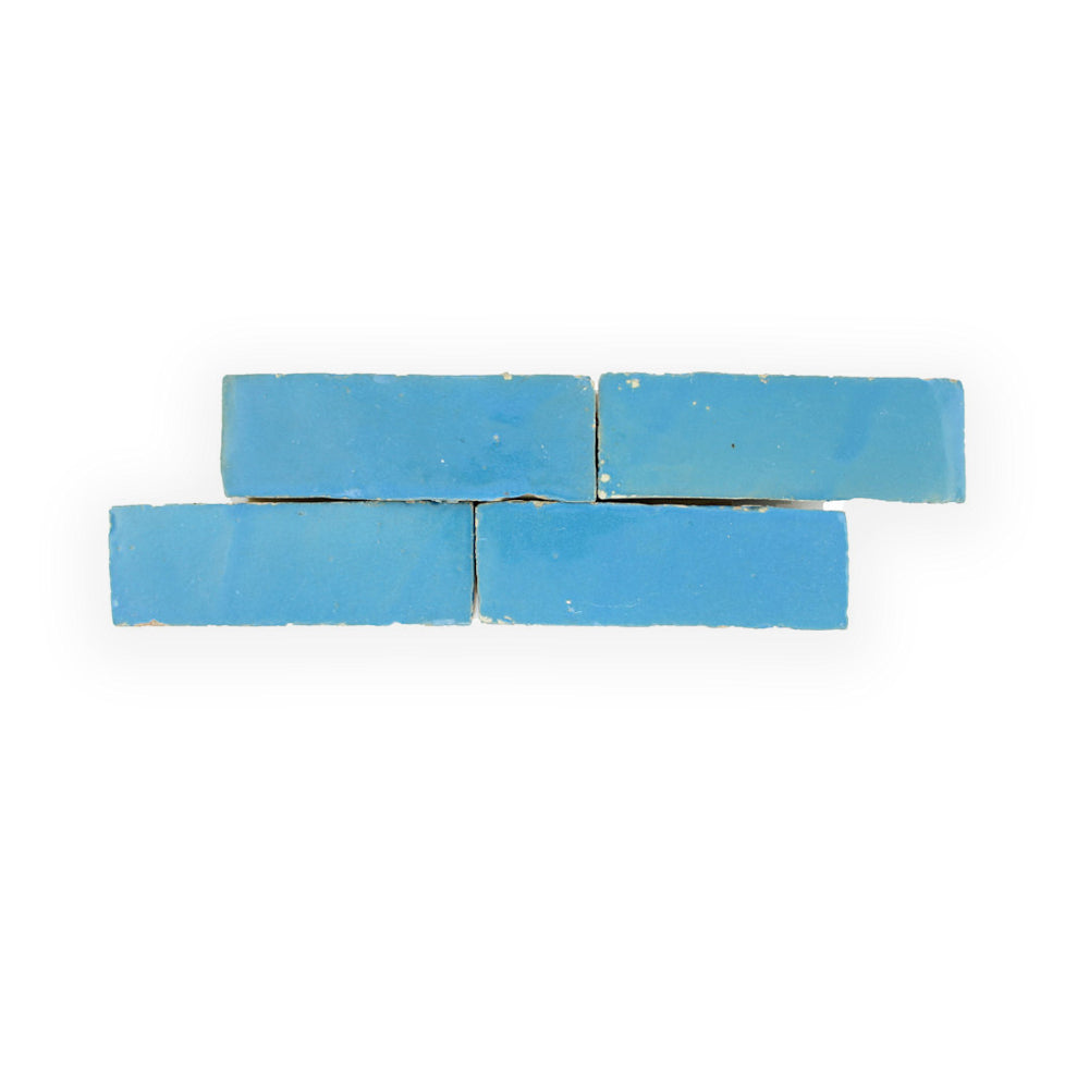 Four Azure (2x6) blue tiles by New York Cement Tile, stacked in two uneven rows on a white background.