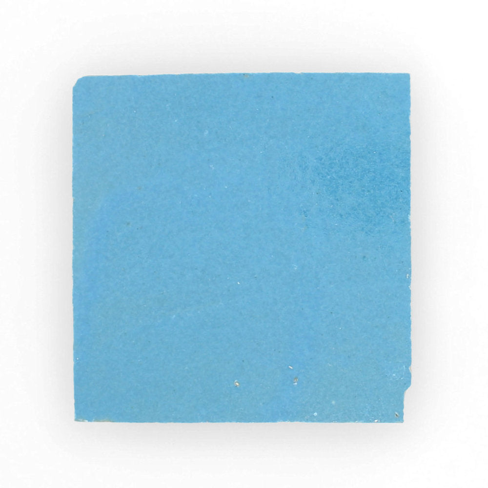 The Azure Sample by New York Cement Tile is a square blue matte Zellige tile with rough edges on a white background.