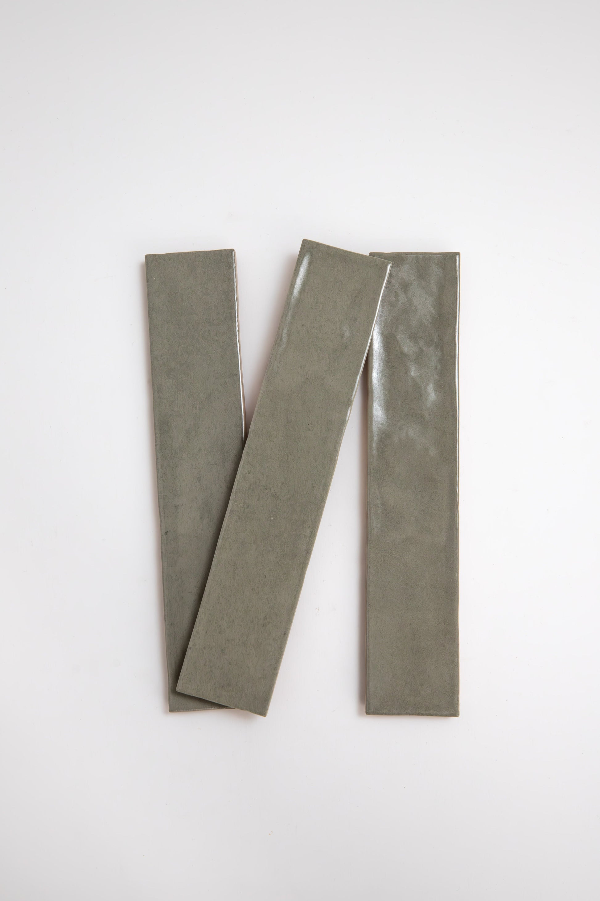 Three long, narrow Skye Green tiles by Cottage Ivy are arranged diagonally on a plain white background.