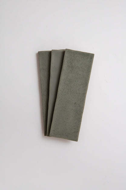 Three rectangular Skye Green tiles by Cottage Ivy fanned out on a plain white background.