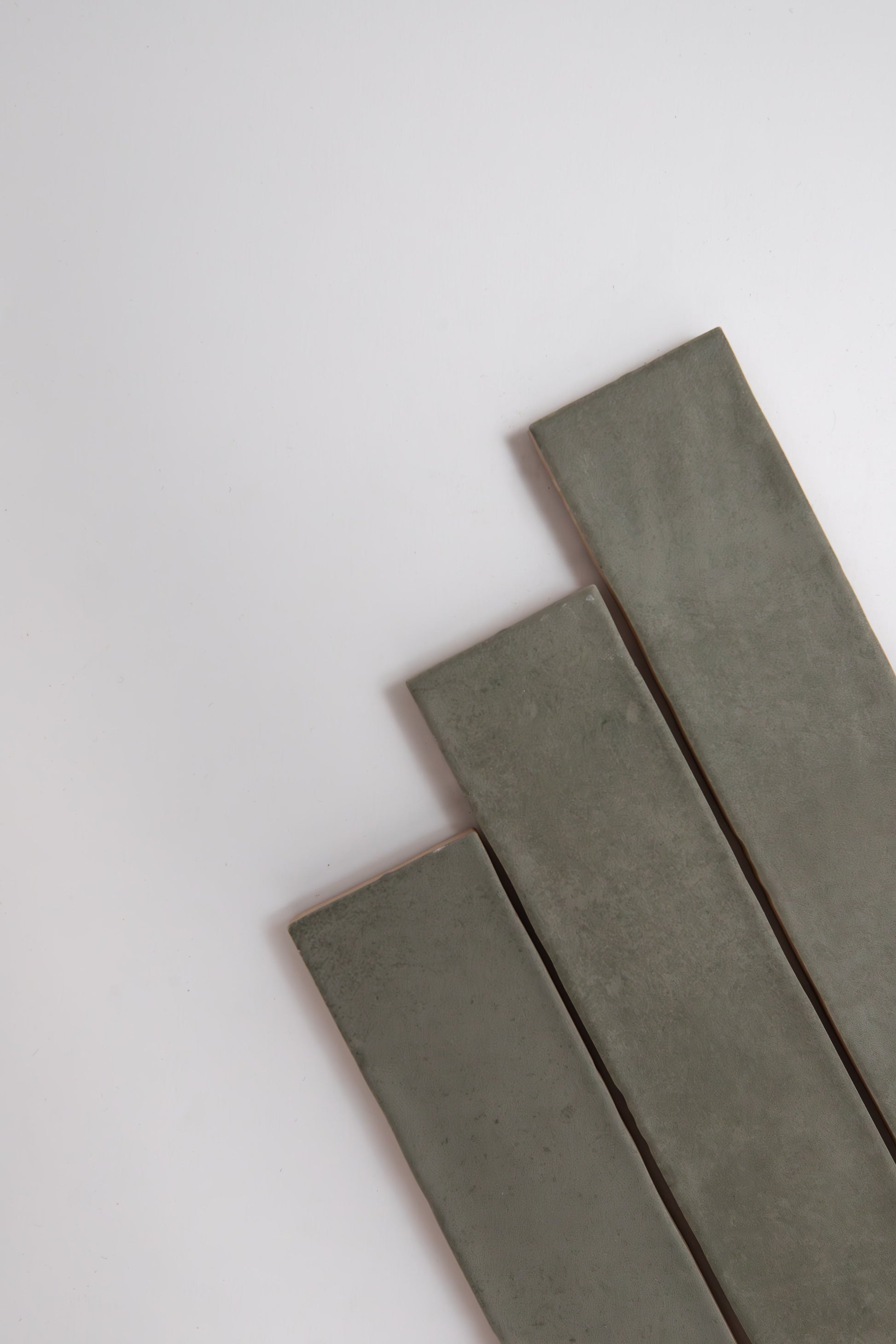 Three Skye Green rectangular tiles by Cottage Ivy are arranged diagonally on a white background.