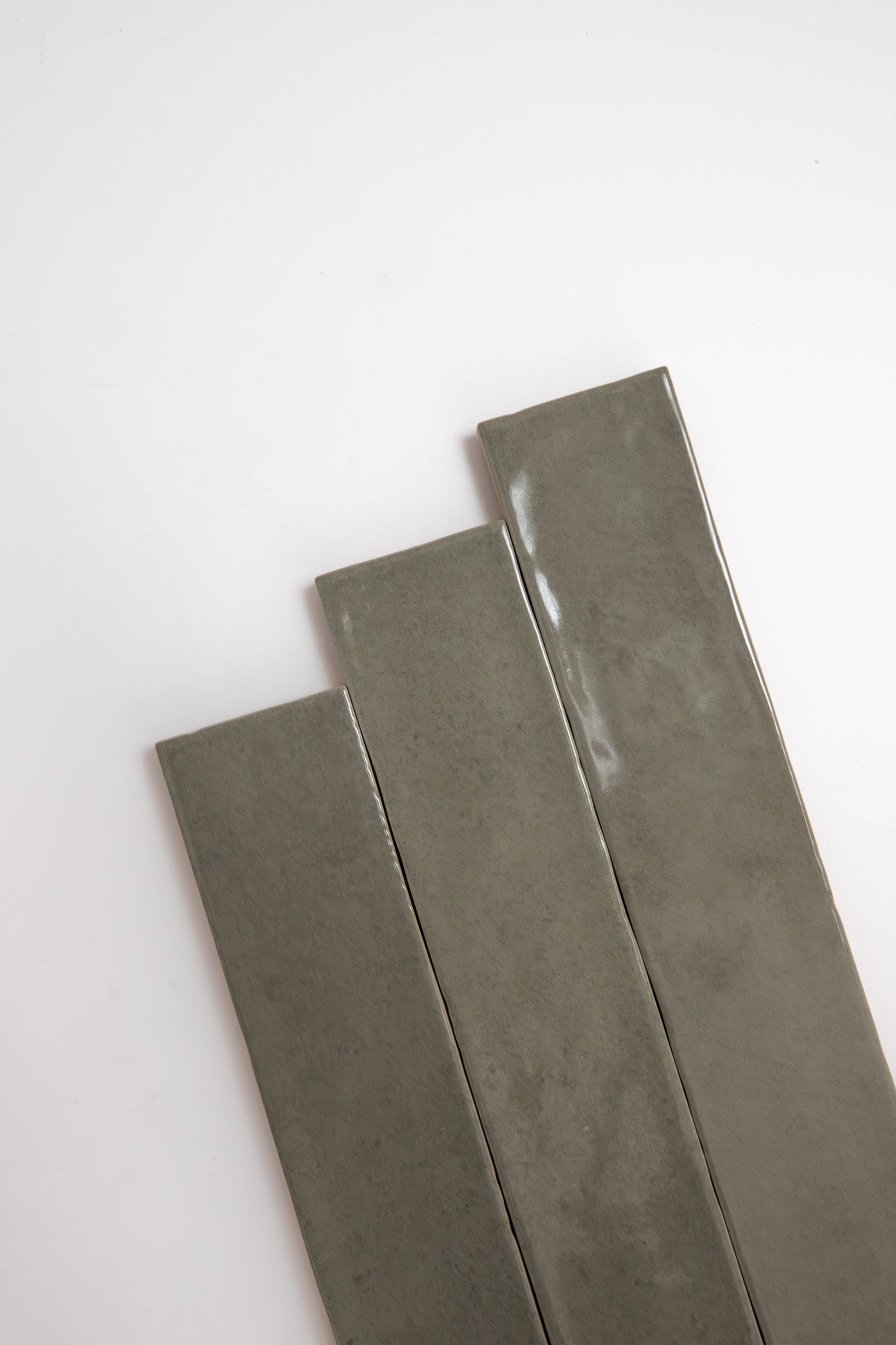 Three long, rectangular Skye Green, Extra Sample tiles by Cottage Ivy arranged diagonally on a white background.