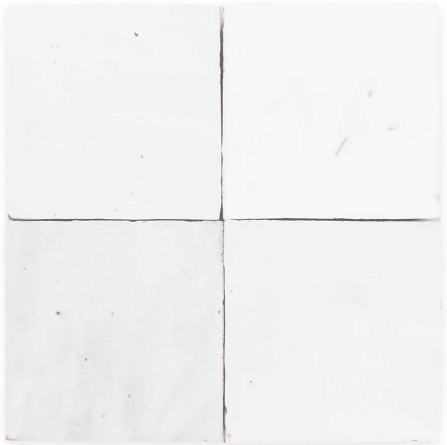 Four Frost tiles by New York Cement Tile, white and handcrafted, show subtle marks and cracks on surfaces and edges.