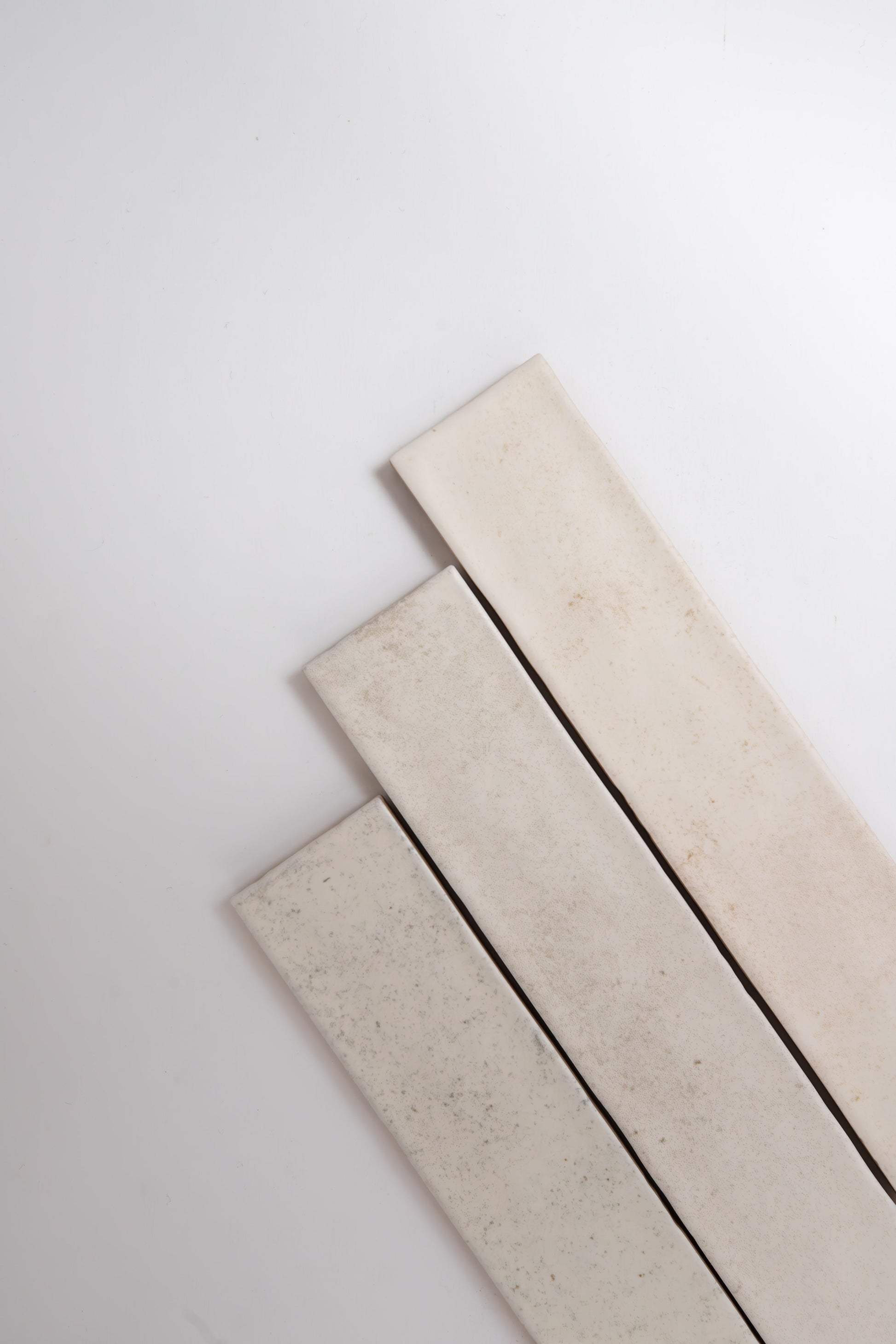 Three Snowshill White samples by Cottage Ivy are laid diagonally on a plain white background.