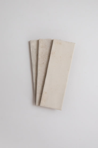 Three Snowshill White sample tiles by Cottage Ivy are fanned out on a white background.