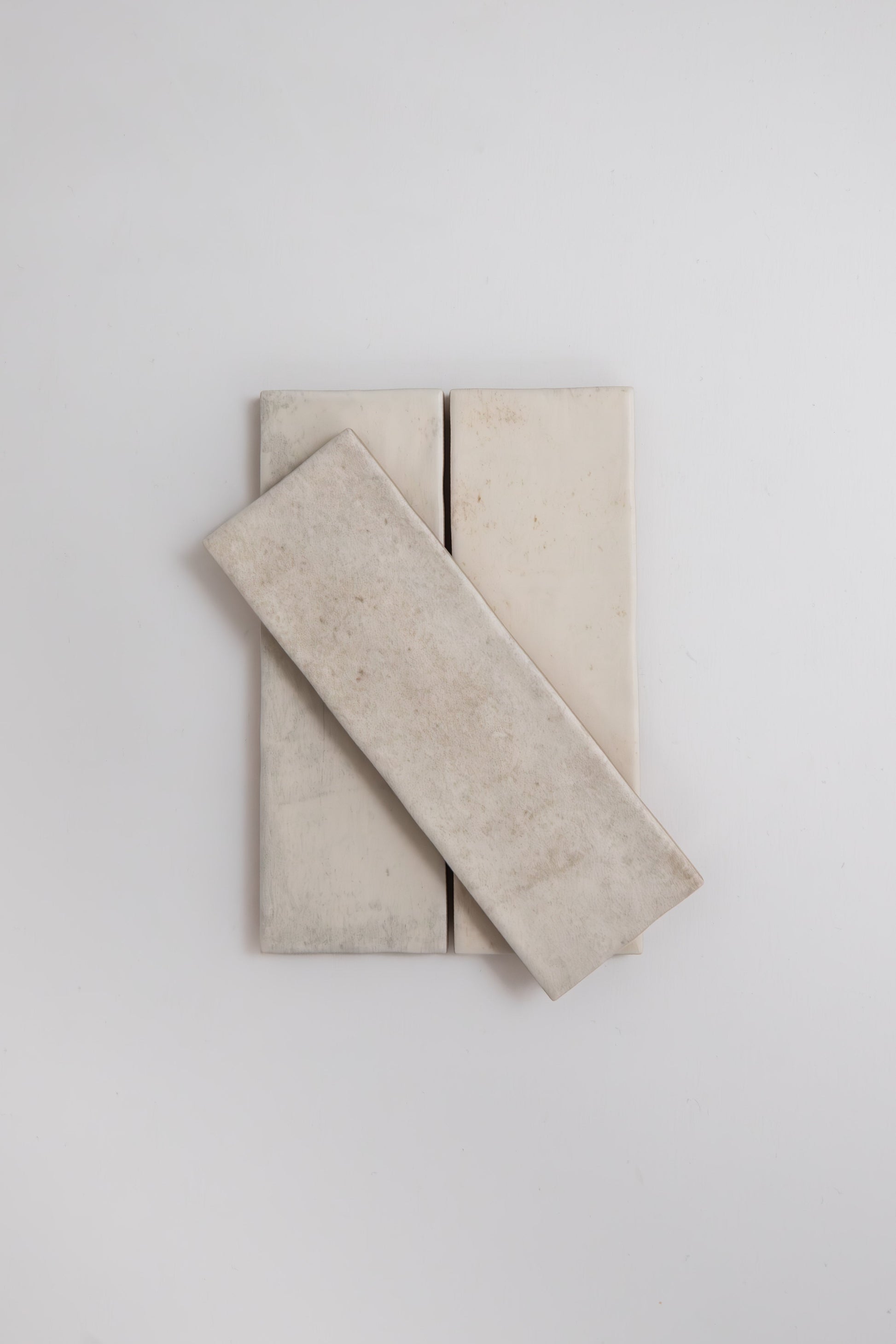Three Snowshill White tile samples by Cottage Ivy, with one tile diagonally stacked over two vertical tiles.