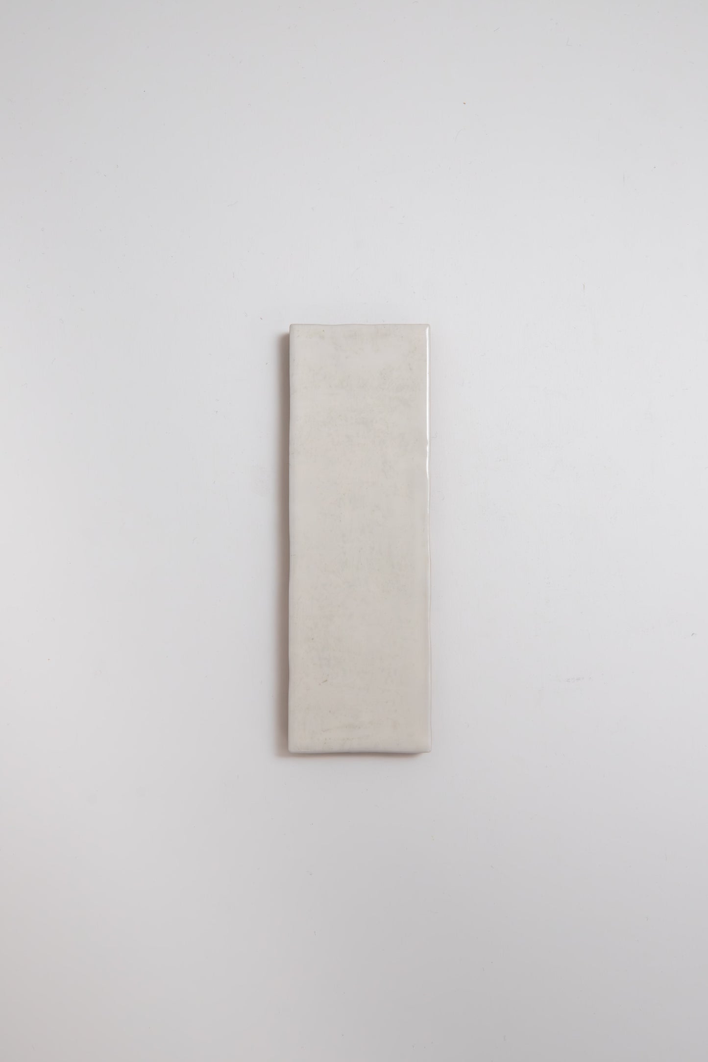 A single Snowshill White tile sample by Cottage Ivy is centered on a plain white background.