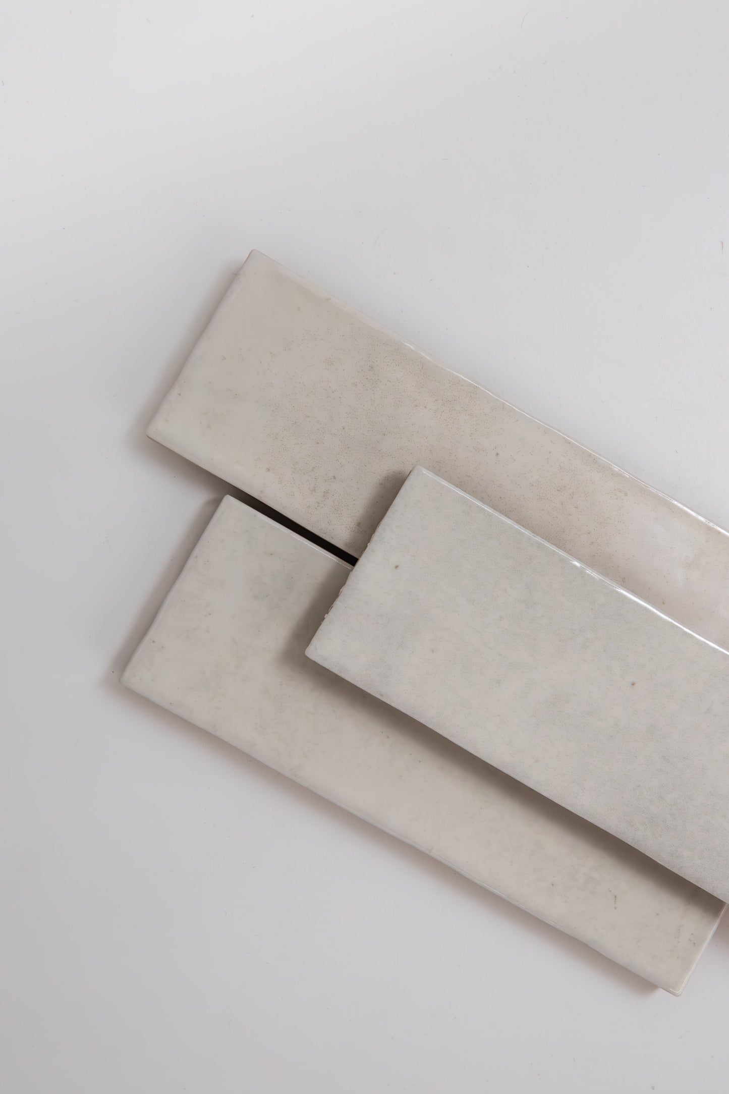 Two Snowshill White, Extra Sample tiles by Cottage Ivy overlap on a plain white background.