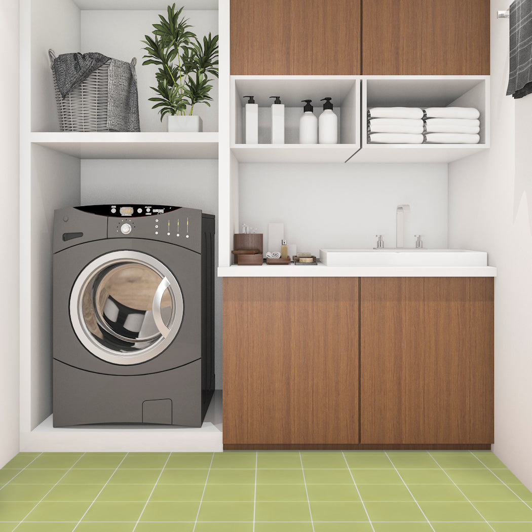 Modern laundry room with New York Cement Tile 3325-Solid green floor, front-load washer, sink, wood cabinets, and shelving.