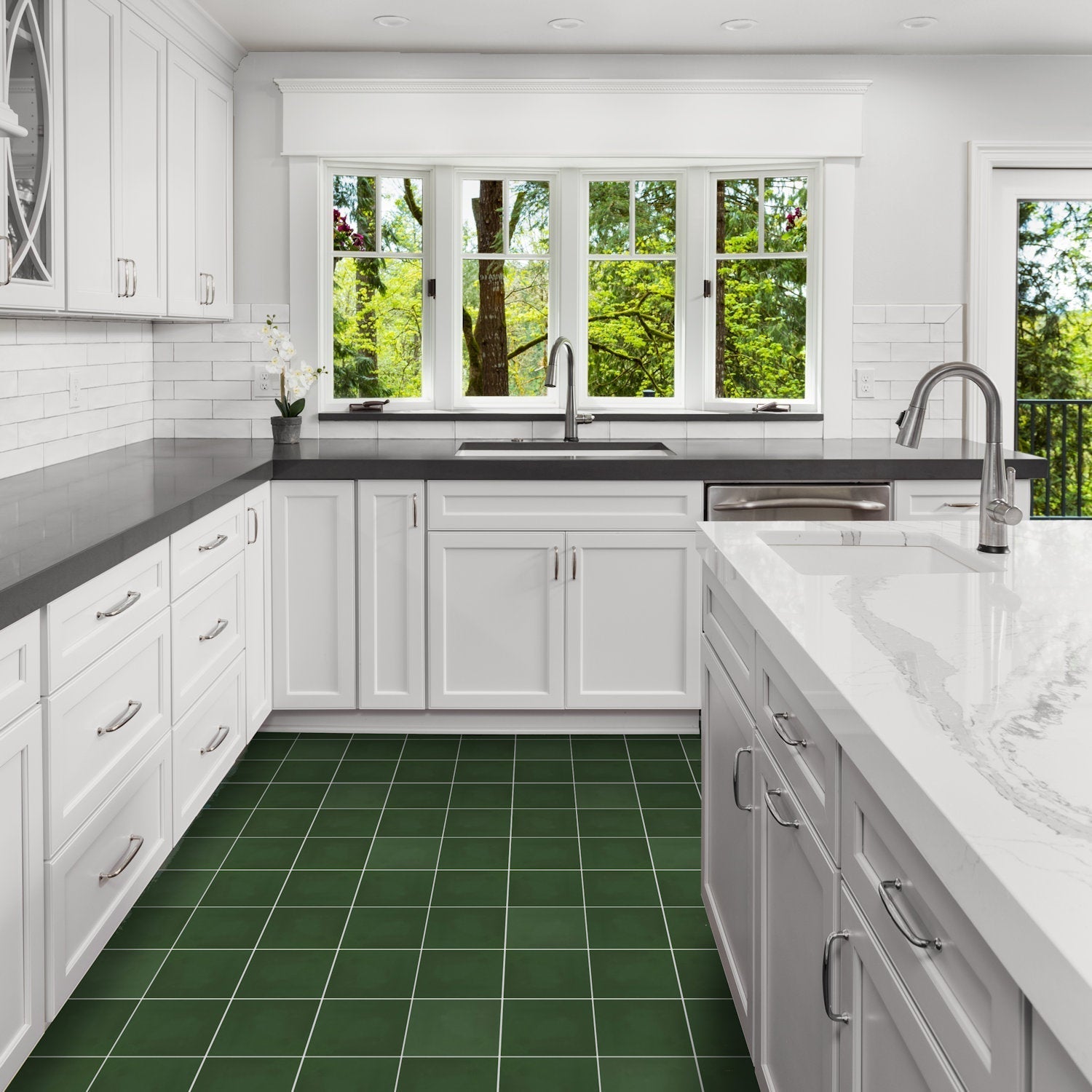 Bright kitchen with white cabinets, dark counters, and New York Cement Tile 3314-Solid 8x8 green tiles overlooking trees.
