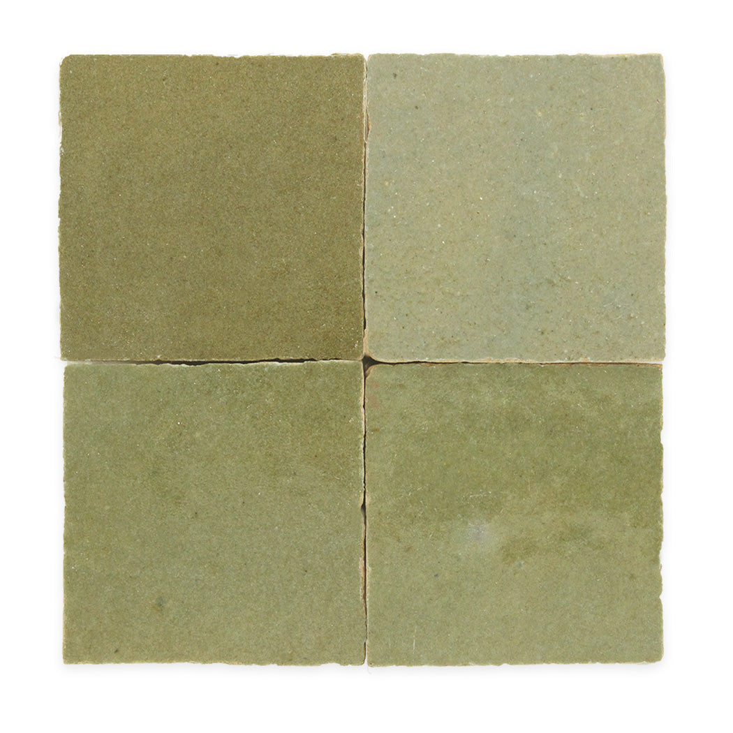Four square, greenish-beige ceramic tiles arranged in a two-by-two grid on a white background.