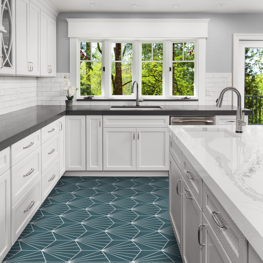 Bright kitchen with white cabinets, dark counters, and blue NH23-036 tiles from New York Cement Tile. Greenery through windows.