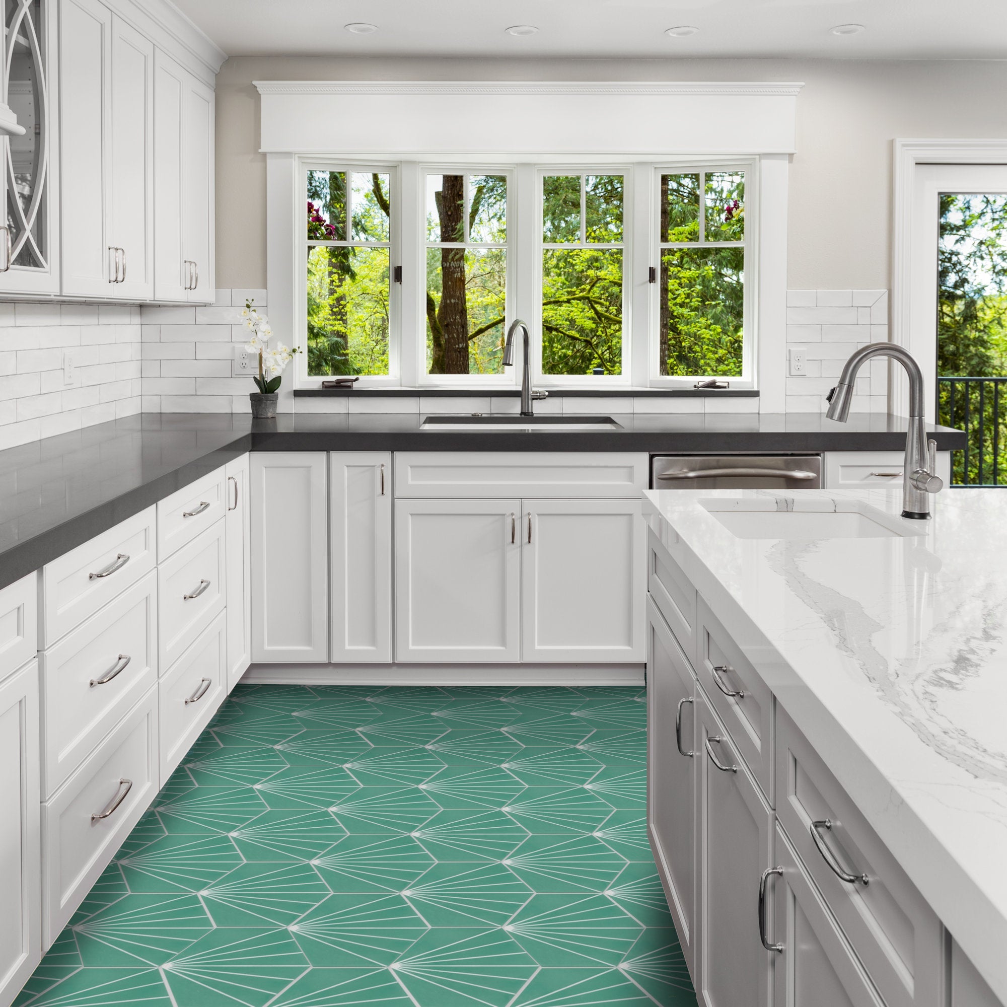 Bright kitchen with white cabinets, gray counters, and NH23-036 green tile floor by New York Cement Tile; tree views outside.
